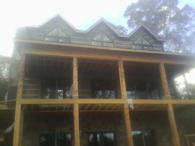 Dormers and porch framing on a large log home under construction — Roof Coating work by our crew in Shokan